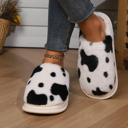 Cozy cow-print plush slippers with soft, fluffy material and non-slip soles for warm, comfortable indoor wear