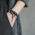 Ethnic style black hair crystal bracelet with white crystal tassel showing lacing construction