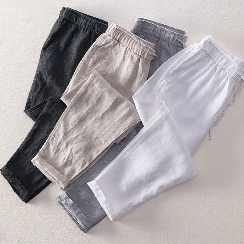 Men's straight leg linen trousers in dark grey, shown laid flat.