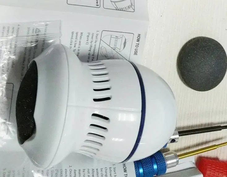 Beige and white USB-charged electric foot file grinder with vacuum system and two diamond grinding heads.