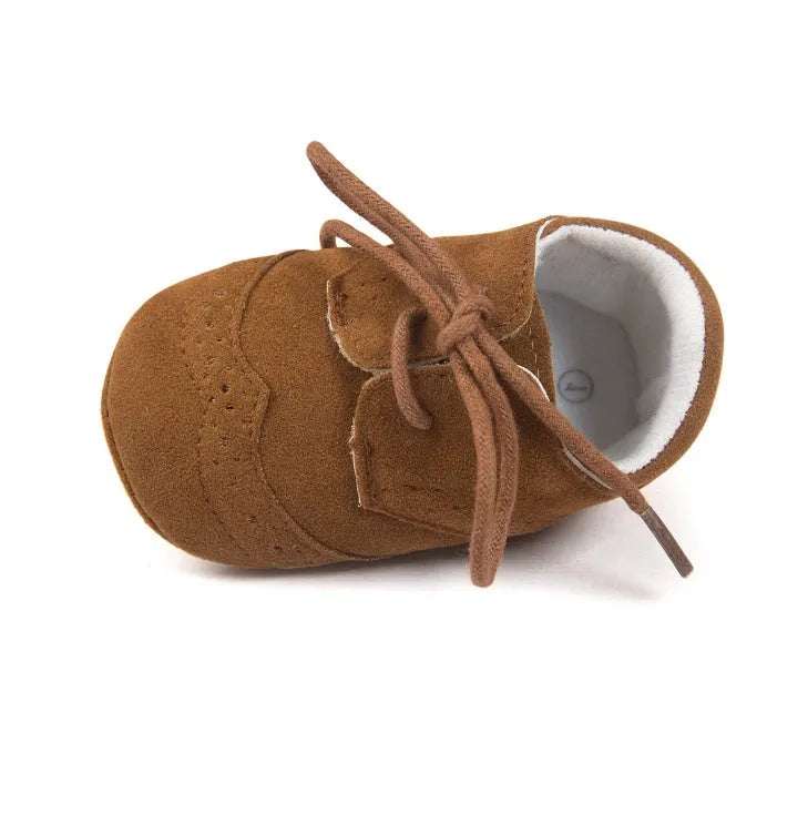 Vintage-style soft-soled baby shoes in synthetic leather, shown in light brown.