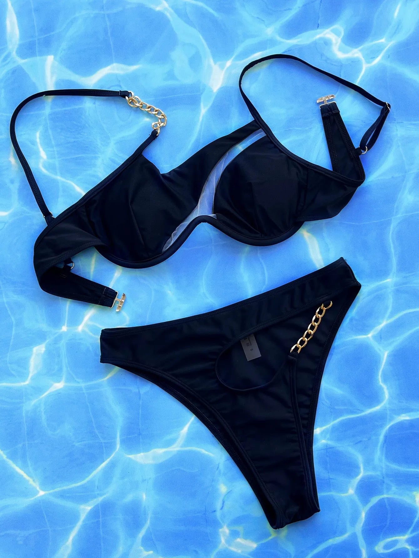 Black women's two-piece hollow split swimsuit made of nylon fabric.