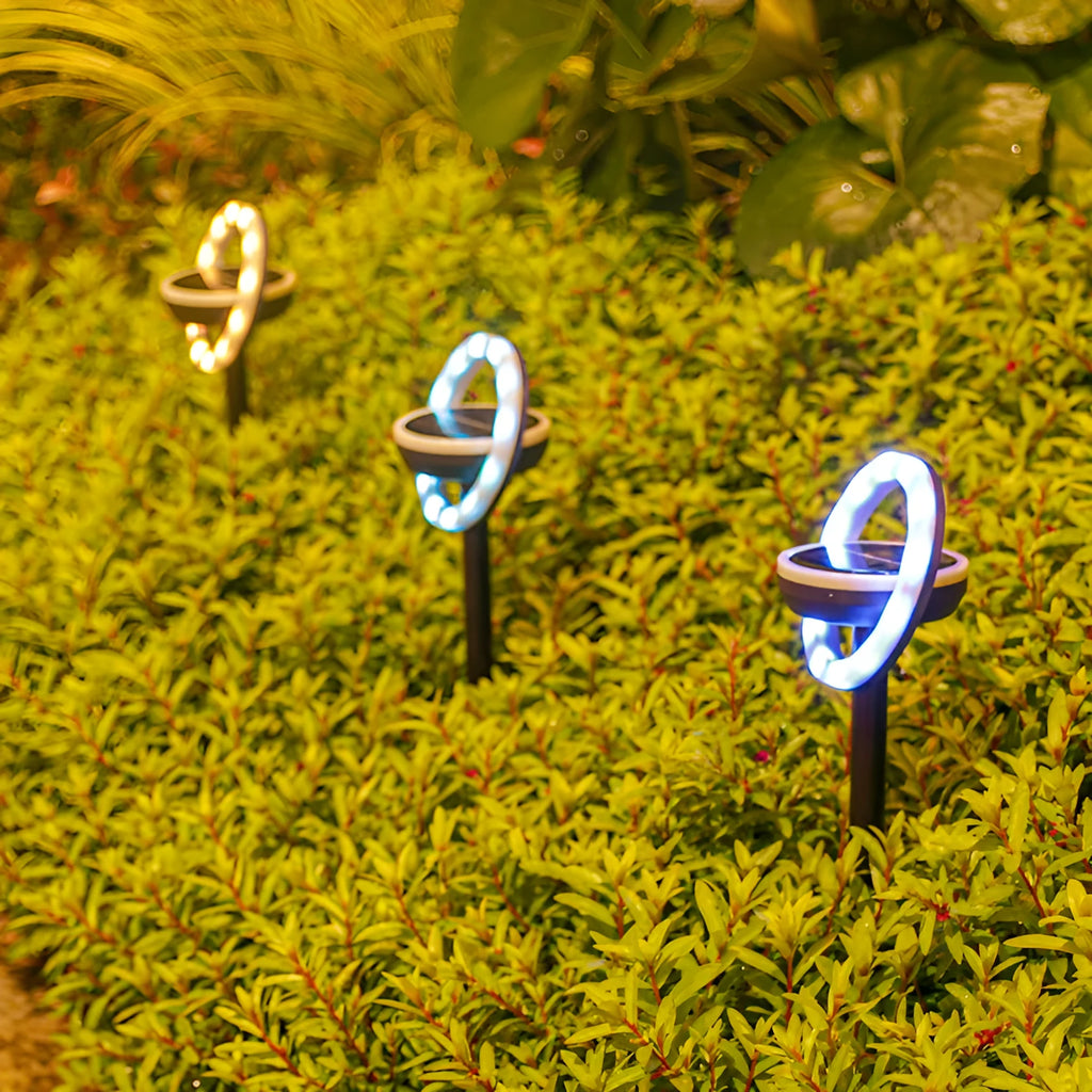 Solar-powered rotating lawn light with 12 LEDs in garden setting