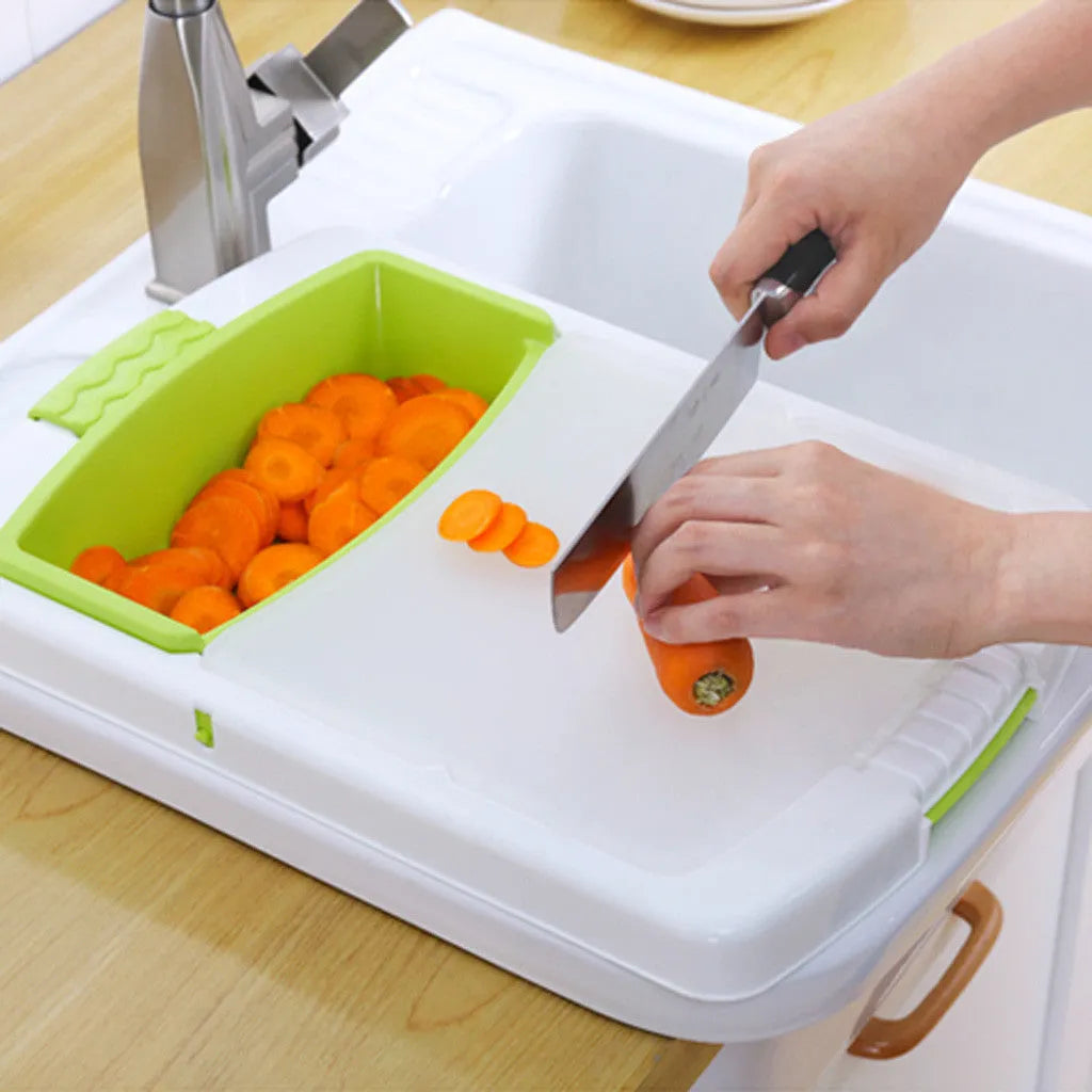 Green sink-mounted kitchen cutting board with drain holes and a storage trough for vegetables.