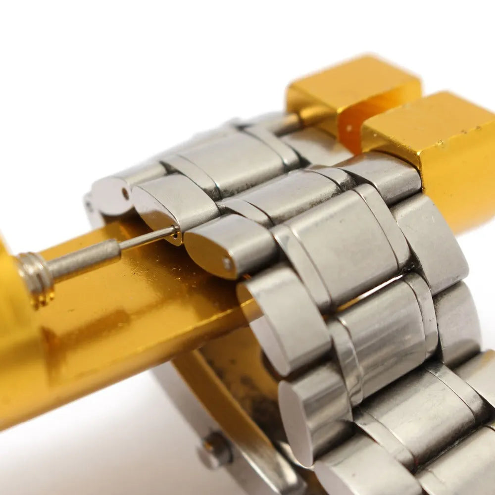 Gold metal watch link remover tool on white background, 6.4cm long, with three small thimbles