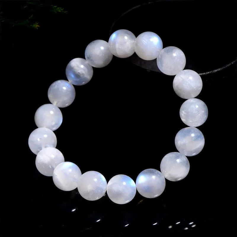 Natural blue moonlight round moonstone bead bracelet on a wrist, showing polished gemstone surface.