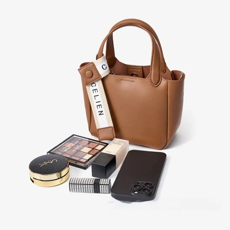 Brown cattlehide leather cross body bucket bag with square vertical shape and visible stitching