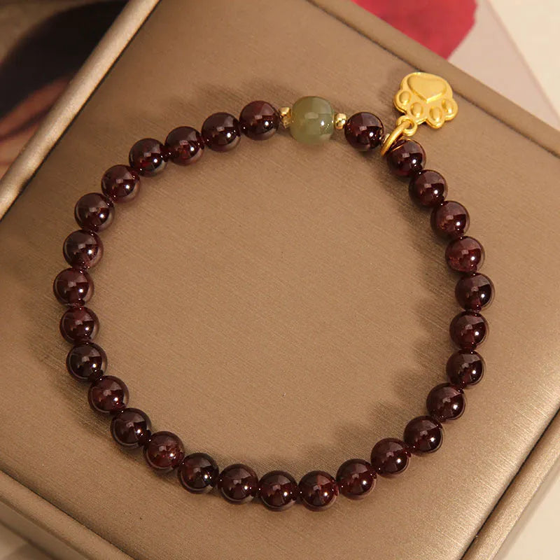 Women's crystal bracelet with a cat's paw garnet motif on a wrist.