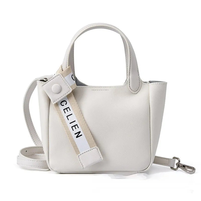 Brown cattlehide leather cross body bucket bag with square vertical shape and visible stitching