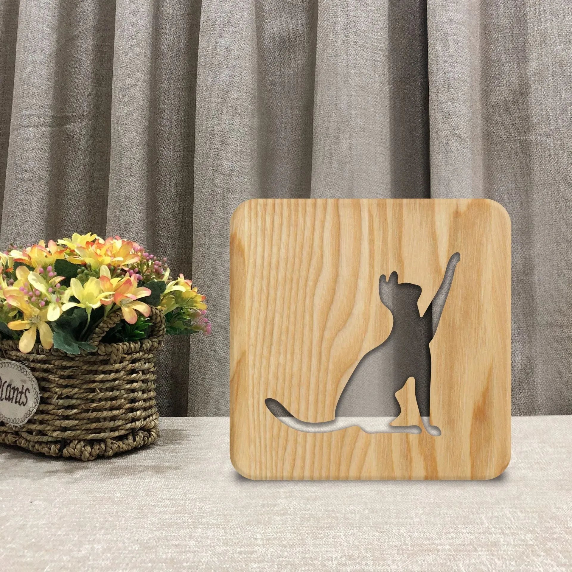 Solid wood 3D night light with hollow cat design on a table