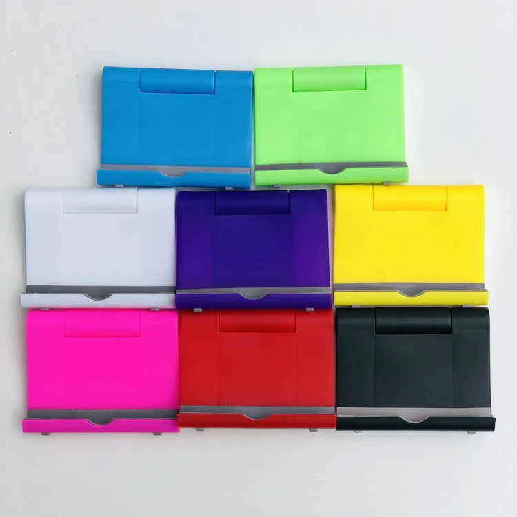 Folding phone and tablet stand in PP and TPR, about 10cm by 8cm by 2cm, in eight colours