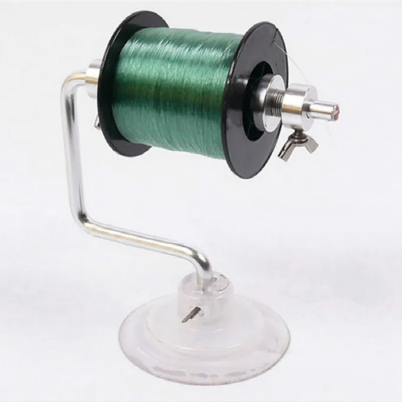 Silver aluminium fishing reel winder with adjustable tensioner and suction cup base on smooth surface