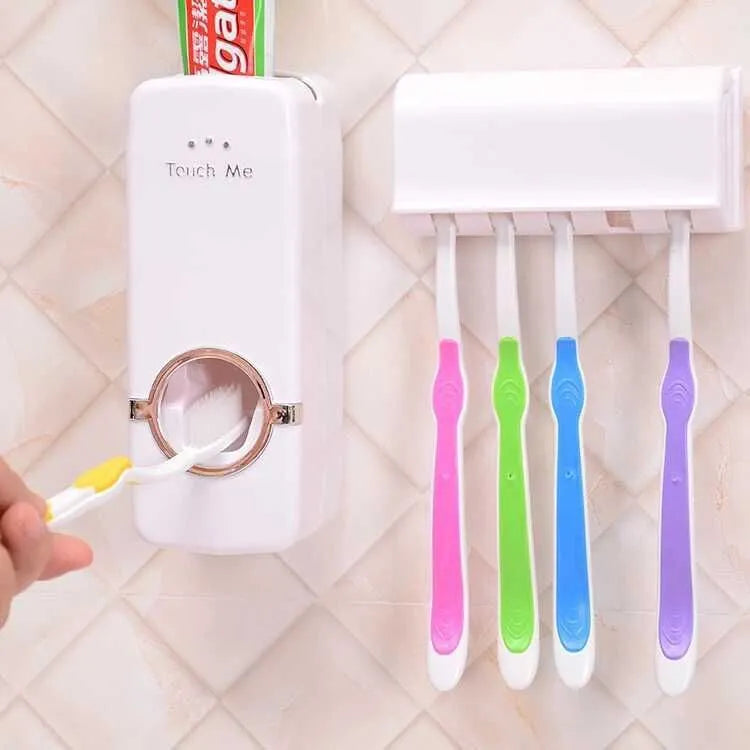 White bathroom accessories set with toothpaste dispenser and toothbrush holder mounted on smooth tile surface