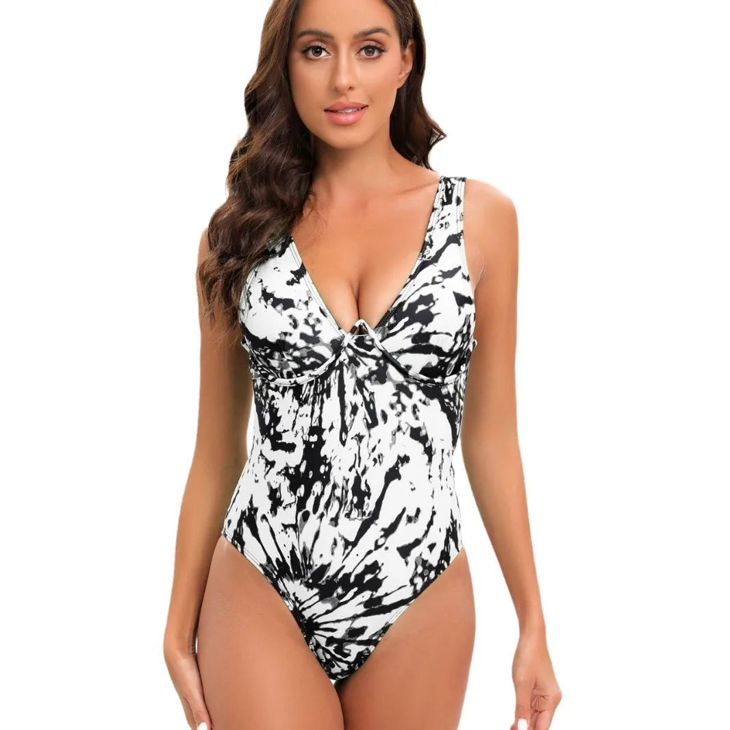 Women's tie-dye print one-piece swimsuit on a hanger showing black, pink, green, and blue colour options.