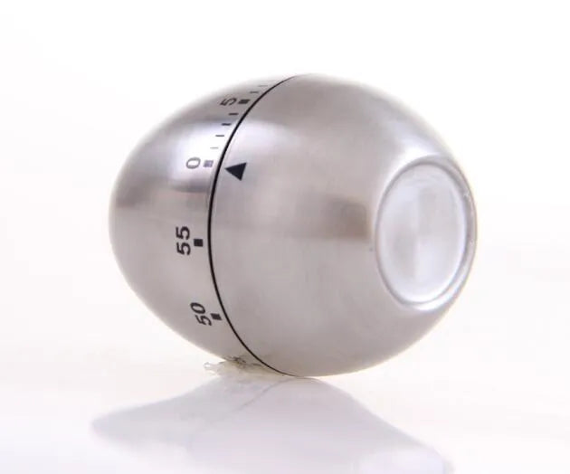 Stainless steel egg-shaped mechanical kitchen timer on a kitchen counter