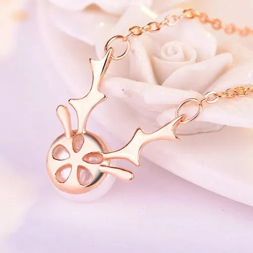Small elk pearl pendant in copper with gold finish, front view against white background