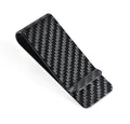Black glossy striped carbon fibre money clip on a flat surface showing its slim profile and textured pattern