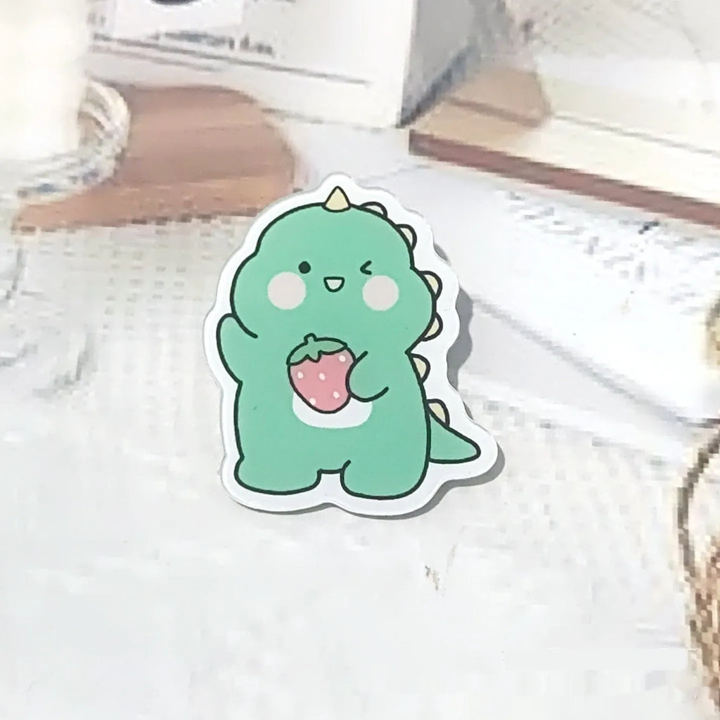 Cartoon dinosaur acrylic badge brooch with printed design and pin fastening, shown in one of twelve colour styles