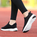 Women's running shoes in black, pink, and white with a fly weaving upper and wear-resistant outsole.