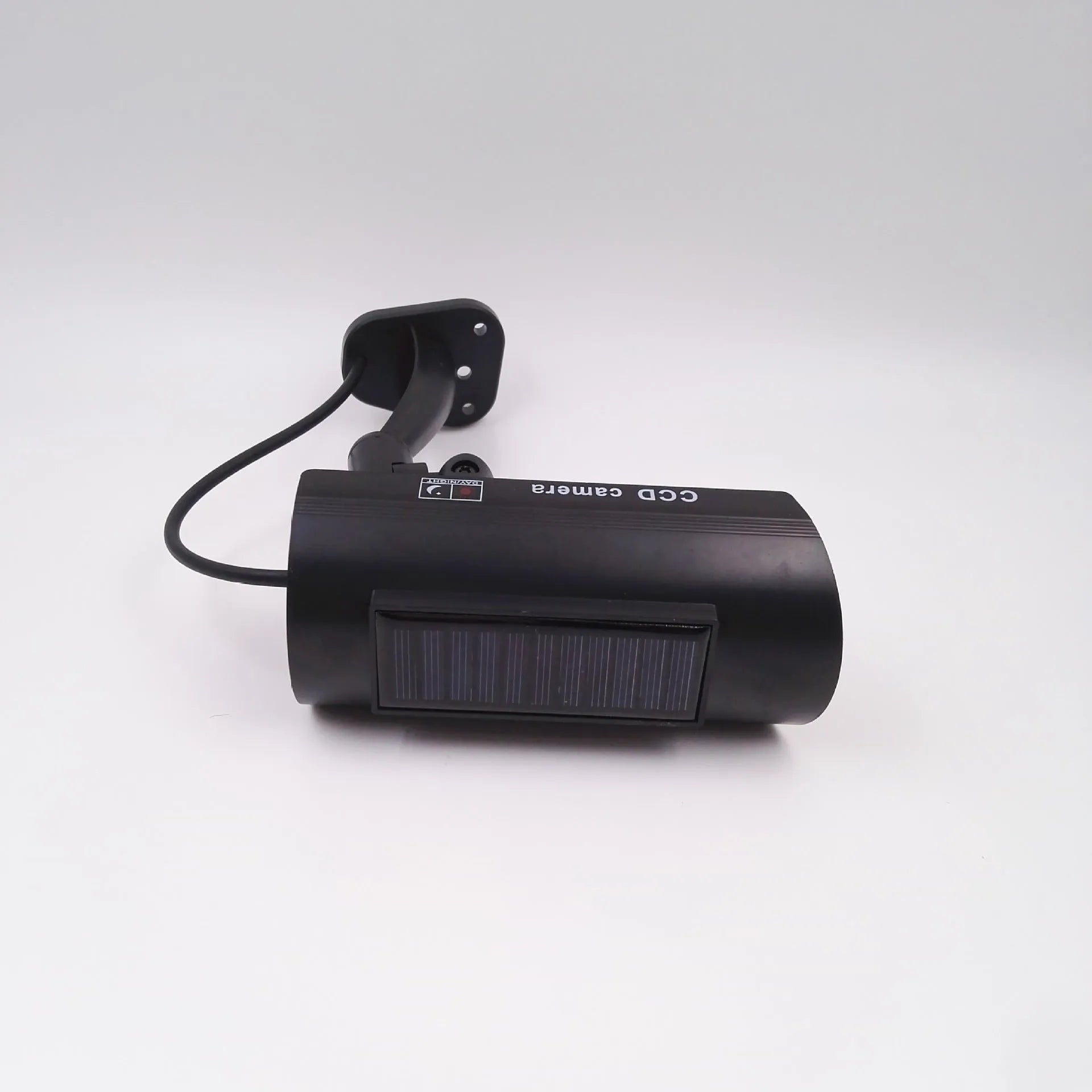 Black plastic solar-powered fake gun security camera with visible solar panel and spot light.
