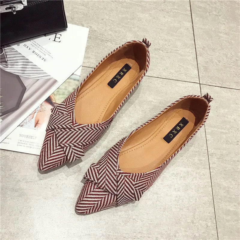 Red and black women's pointed toe flat shoes with a shallow mouth design and low flat heel.