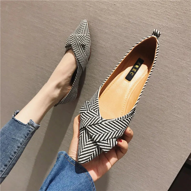 Red and black women's pointed toe flat shoes with a shallow mouth design and low flat heel.