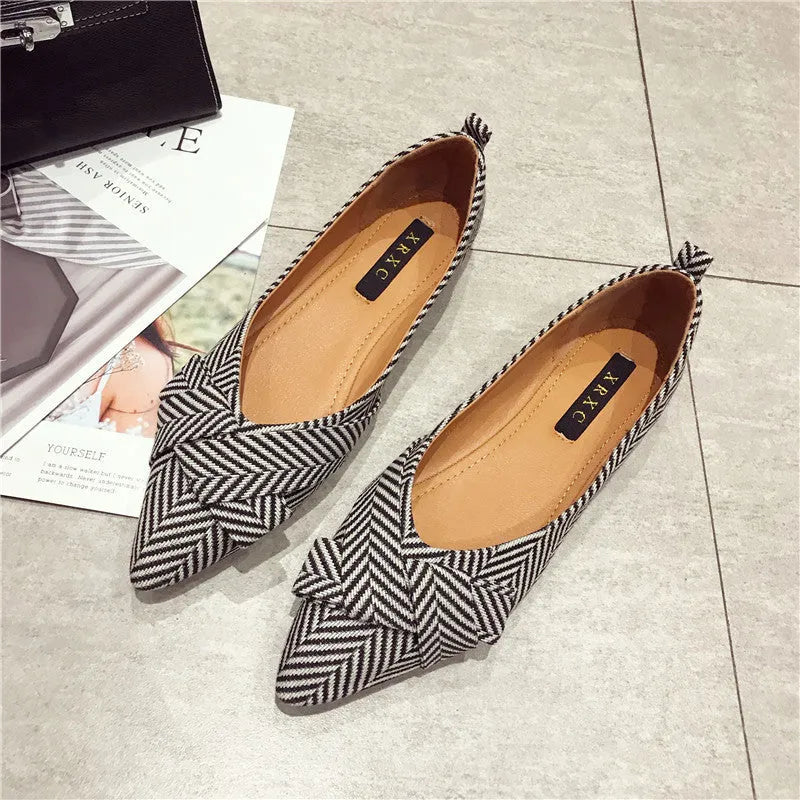 Red and black women's pointed toe flat shoes with a shallow mouth design and low flat heel.