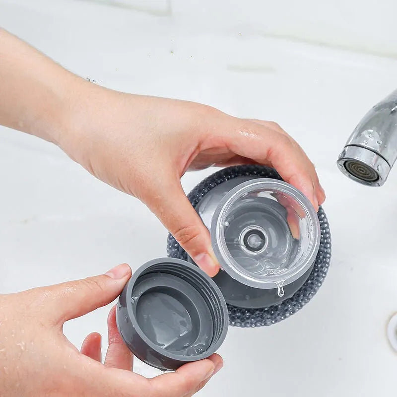 Push-type kitchen soap dispensing scrubber brush with PET construction on a kitchen counter.