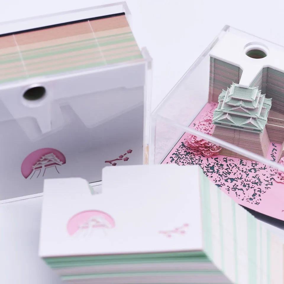 Three-dimensional specialty paper model of the Tianshou Tower from Spirited Away on a desk.