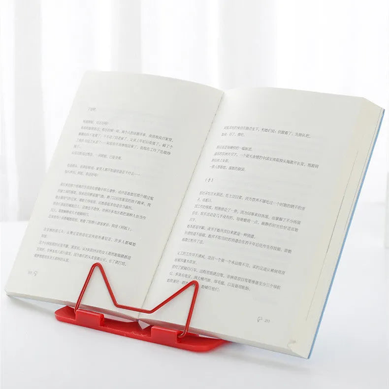 Multifunctional metal and plastic reading frame in blue colour on a desk holding a book upright.