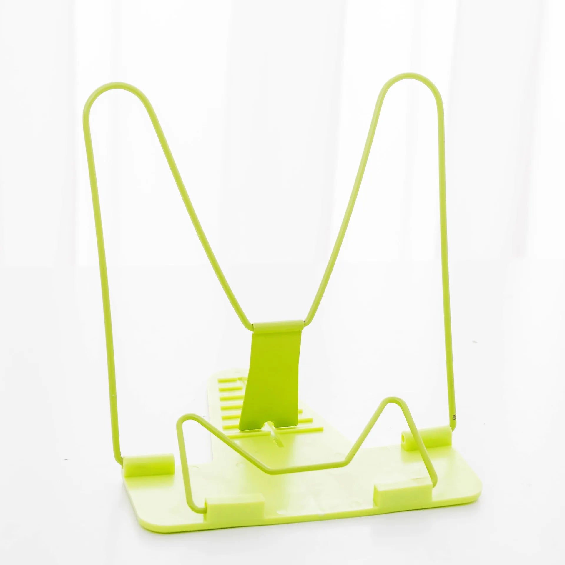 Multifunctional metal and plastic reading frame in blue colour on a desk holding a book upright.