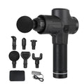 Black electric muscle massage gun with multiple interchangeable heads on a table.