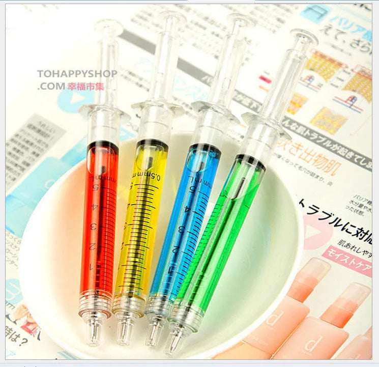 Blue syringe ballpoint pen 12.5cm length on a desk, push-type mechanism visible