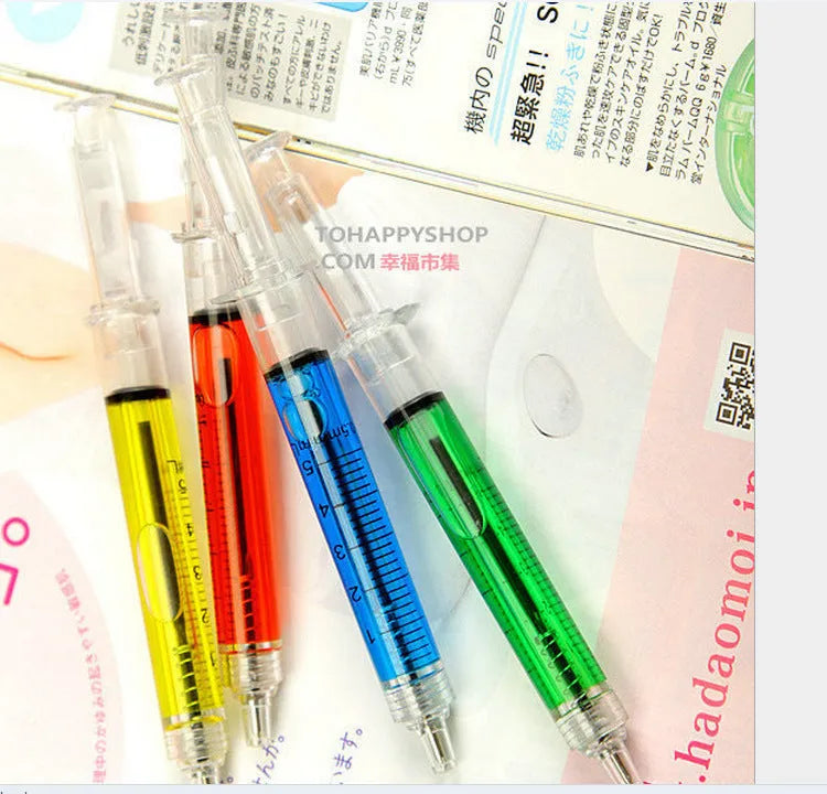 Blue syringe ballpoint pen 12.5cm length on a desk, push-type mechanism visible