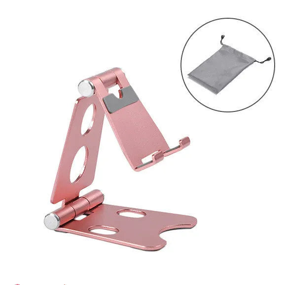 Mini folding metal mobile phone stand on a desktop in gold colour.