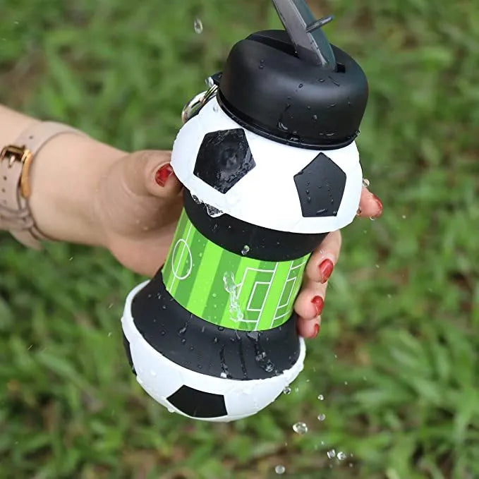 Collapsible white soccer ball shaped silicone water bottle with straw and carrying clip, 18 oz capacity