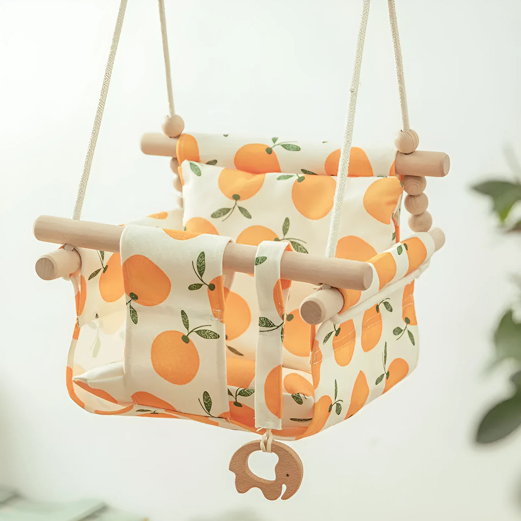Cotton canvas baby swing chair with wooden seat and tassel decoration, hanging indoors.