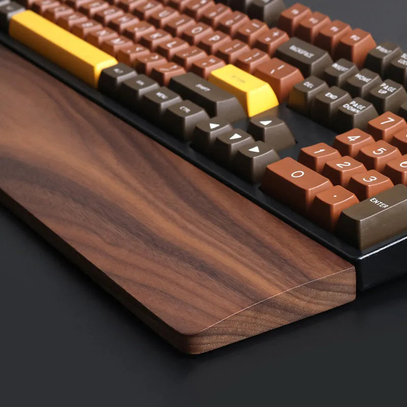 Walnut wood mechanical keyboard wrist rest showing natural wood grain and ergonomic shape