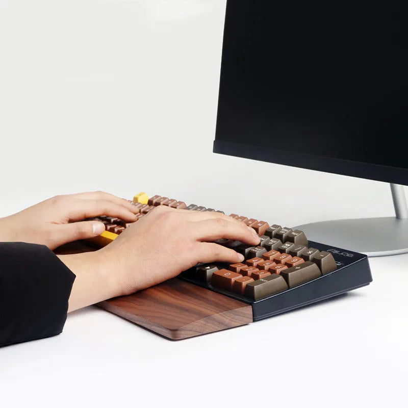 Walnut wood mechanical keyboard wrist rest showing natural wood grain and ergonomic shape