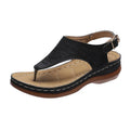 Women's beige wedge heel flip flop sandals with an adjustable buckle strap on a wooden deck.