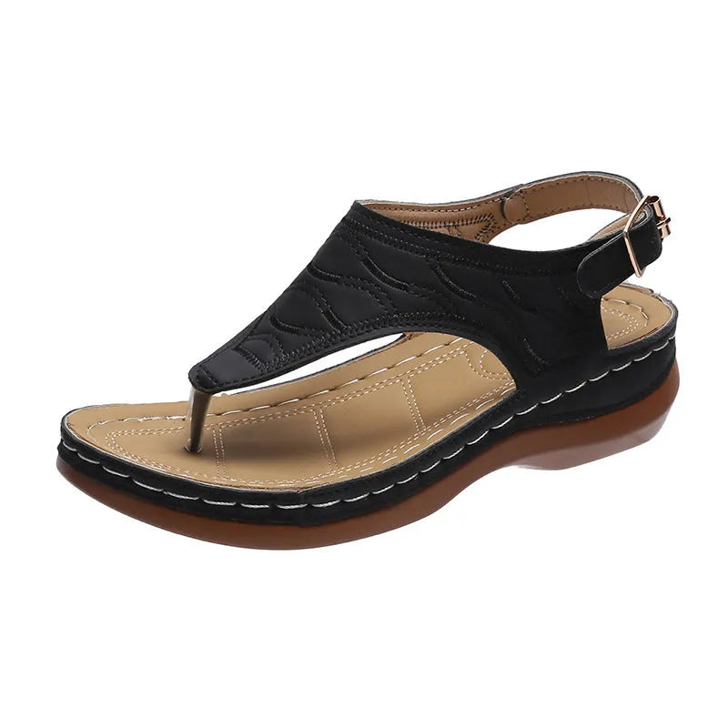Women's beige wedge heel flip flop sandals with an adjustable buckle strap on a wooden deck.