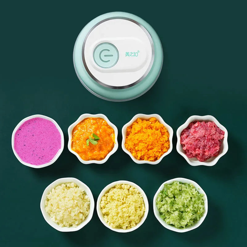White portable electric mini food chopper with transparent cup and stainless steel blade on a kitchen counter.
