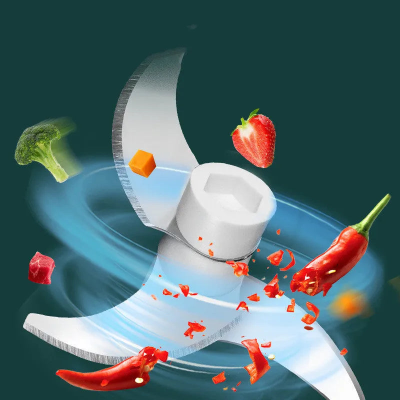 White portable electric mini food chopper with transparent cup and stainless steel blade on a kitchen counter.