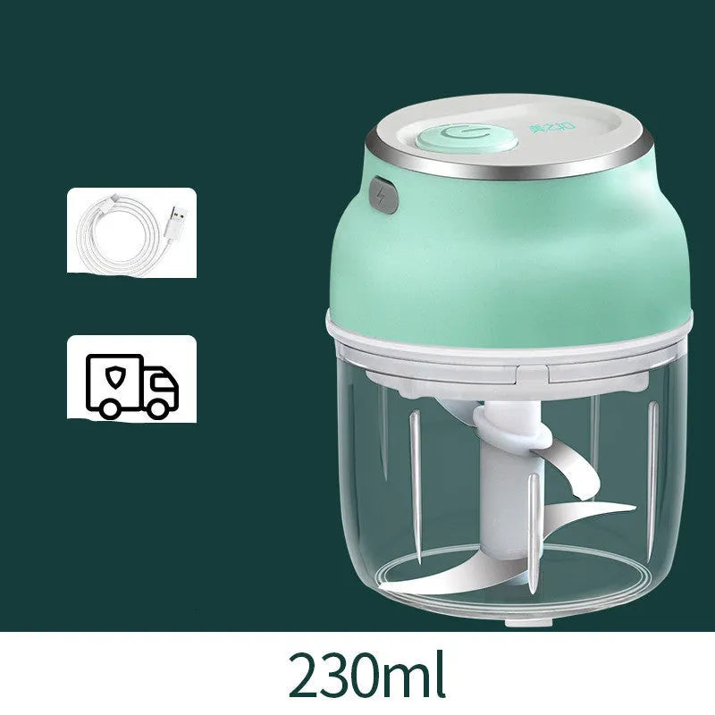 White portable electric mini food chopper with transparent cup and stainless steel blade on a kitchen counter.