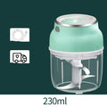White portable electric mini food chopper with transparent cup and stainless steel blade on a kitchen counter.