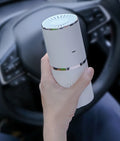 Anion car air purifier in creamy white or green with composite filter, 30 dB, USB and car power supply
