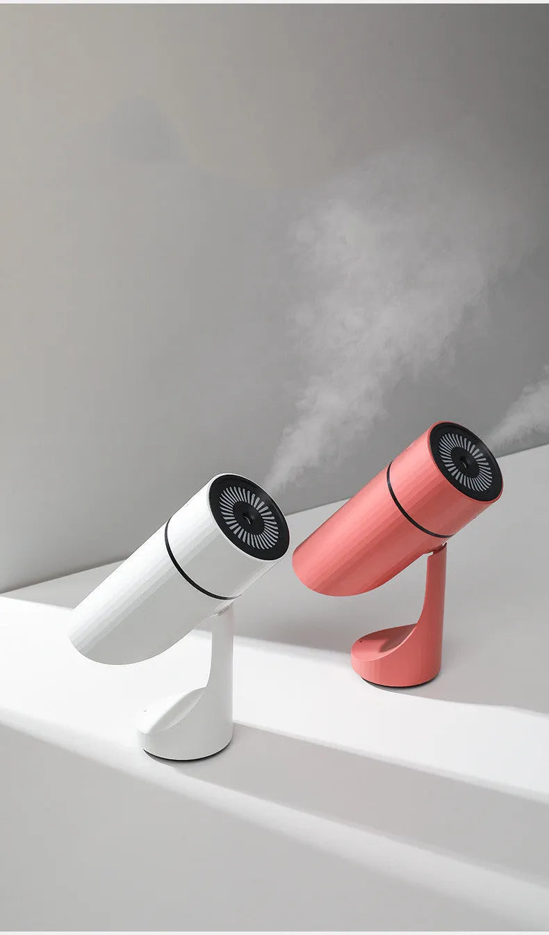 USB desktop humidifier with adjustable angle nozzle, white, with night light on, on a desk