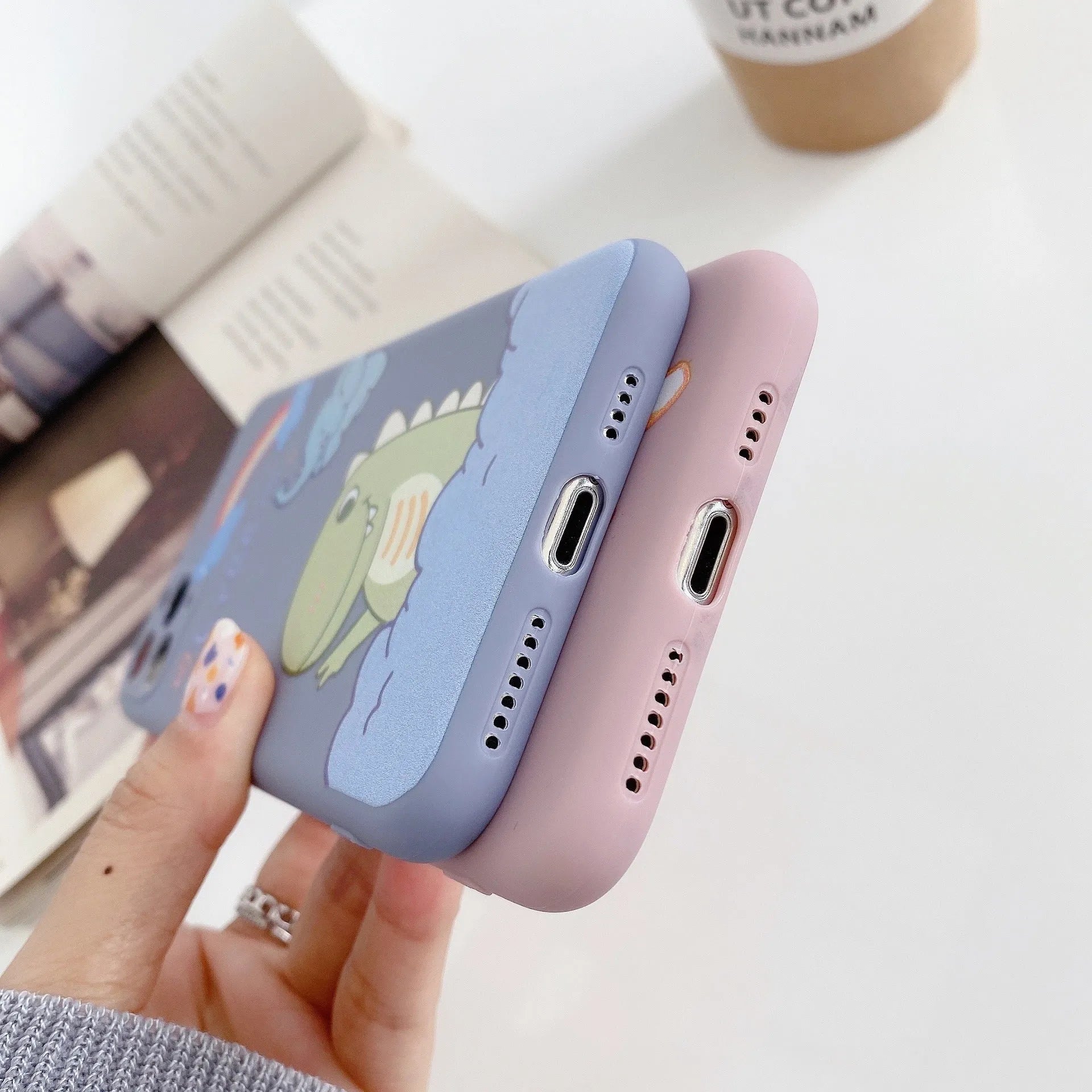 Blue frosted TPU iPhone case with a cartoon dinosaur print on the back.