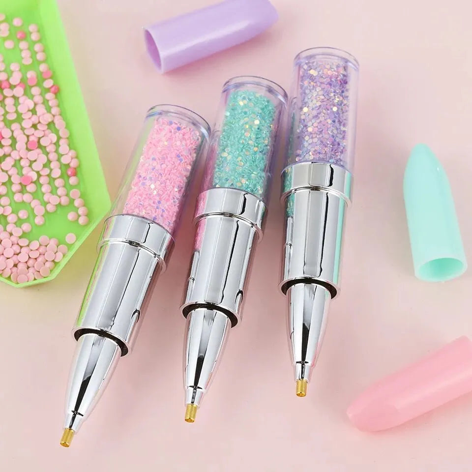 A plastic diamond painting point drill pen for manual diamond placement, shown in pink, purple, and green colour options.