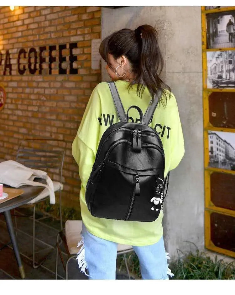 Black soft surface PU leather medium backpack with double straps and a detachable pendant